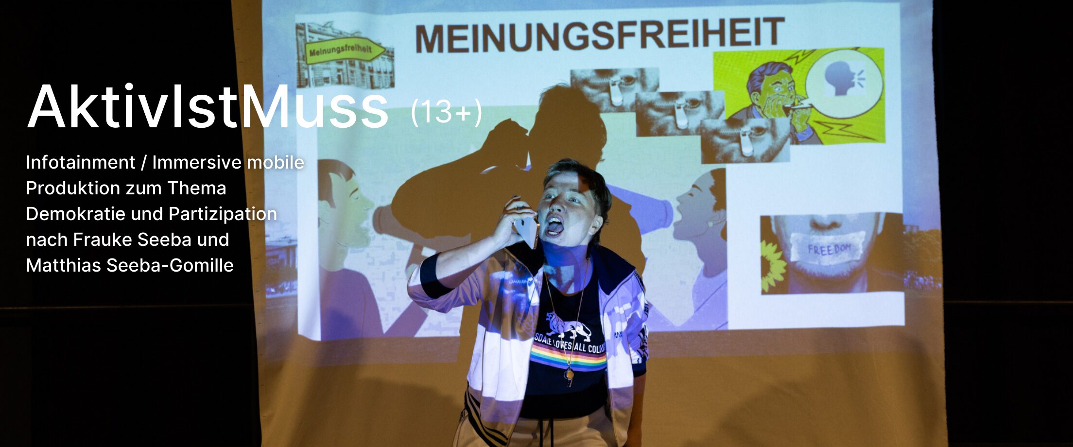 Eine Person schreit in ein Handy vor einer Projektion, bei der das Wort 
