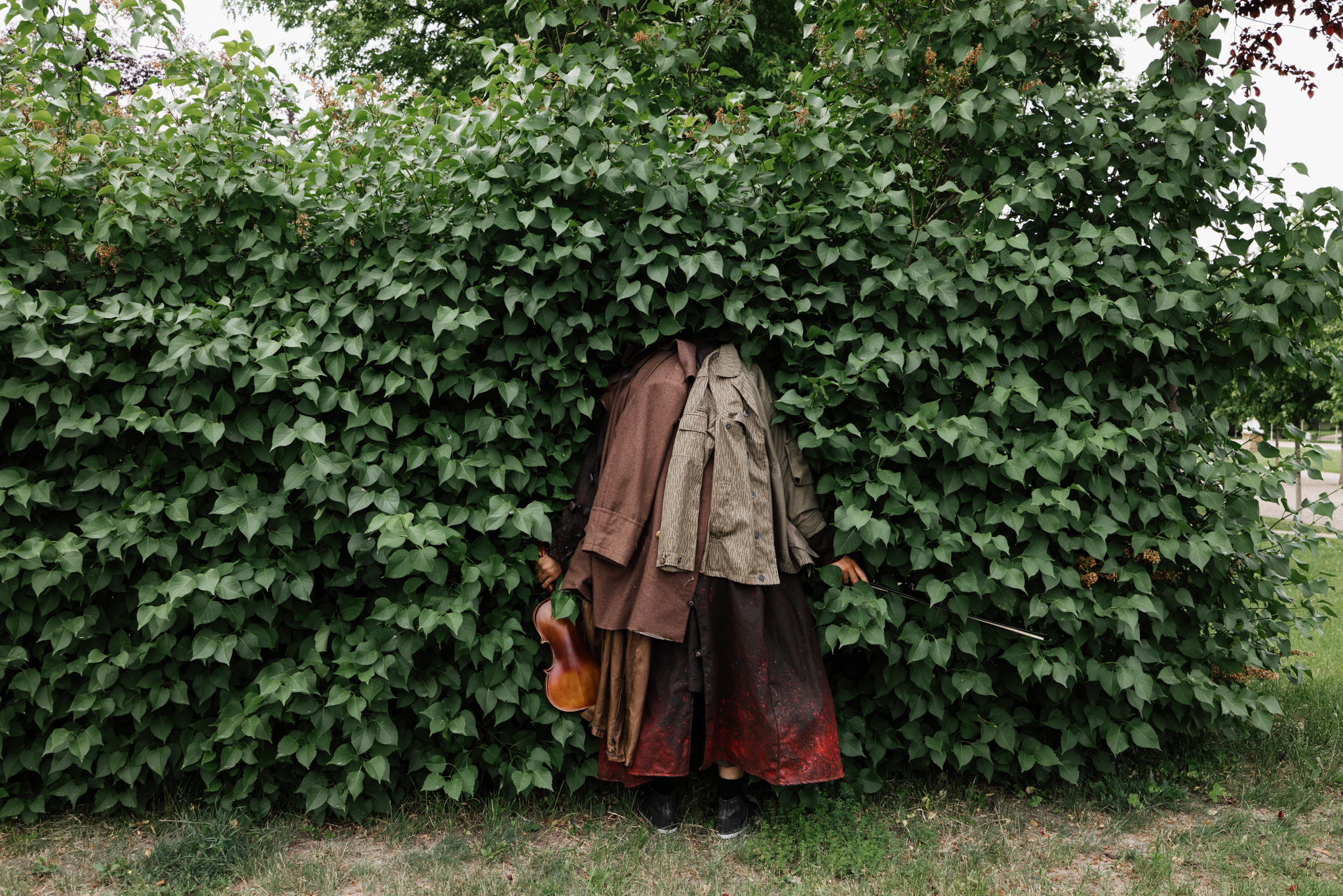 Der Soldat schaut durch eine große Hecke